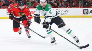 Dallas Stars defenseman Miro Heiskanen (4) controls the puck against Chicago Blackhawks center Jason Dickinson (17) during a game between the Dallas Stars and the Chicago Blackhawks on March 28, 2022 at the United Center in Chicago, IL. (Photo by Melissa Tamez/Icon Sportswire via Getty Images)