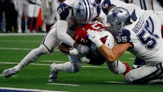 Chase Edmonds #2 of the Arizona Cardinals runs the ball and is tackled by Donovan Wilson #6 and Leighton Vander Esch #55 of the Dallas Cowboys during the first quarter at AT&T Stadium on January 02, 2022 in Arlington, Texas.