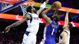 MARCH 29: James Harden #1 of the Philadelphia 76ers shoots a lay up between Kyrie Irving #2 and Dwight Powell #7 of the Dallas Mavericks during the second quarter at Wells Fargo Center on March 29, 2023 in Philadelphia, Pennsylvania.