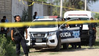 Ministerial police officers secure the area where a clandestine common grave was found, at the Lomas del Aeropuerto neighborhood in El Salto municipality, Jalisco state, Mexico, on June 06, 2018.
