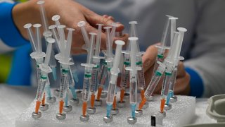 FILE - A nurse prepares vaccines COVID-19 vaccines in Madrid, Spain, Dec. 1, 2021.