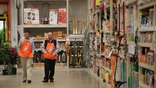 Workers walk through the garden center at a Home Depot store