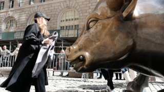 People walk by Wall Street Bull in the Financial District on March 07, 2023 in New York City.