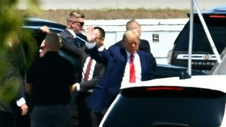 Former US President Donald Trump waves as he boards his plane at Palm Beach International Airport in West Palm Beach, Florida, on April 3, 2023.