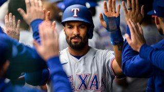 Texas Rangers' Marcus Semien is congratulated after scoring against the Kansas City Royals during the first inning of a baseball game, Wednesday, April 19, 2023, in Kansas City, Mo.