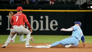 ARLINGTON, TEXAS – APRIL 02: Robbie Grossman #4 of the Texas Rangers slides into second base ahead of the tag of Trea Turner #7 of the Philadelphia Phillies during the sixth inning at Globe Life Field on April 02, 2023 in Arlington, Texas. (Photo by Sam Hodde/Getty Images)