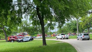 Rescuers search for two men in the Elm Fork of the Trinity River, Sunday, April 9, 2023.