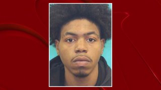 A man is in custody and another man is wanted in connection with a home invasion robbery that led to a shootout which ended with two suspects killed last month in Garland, police say.