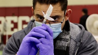 A health worker prepares a flu vaccine shot before administering it to a local resident in Los Angeles, the United States, on Dec. 17, 2022.