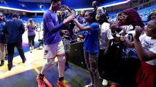 Phoenix Mercury's Brittney Griner, left, talks with fans after preparing for the team's WNBA basketball game against the Dallas Wings, Wednesday, June 7, 2023, in Arlington, Texas.