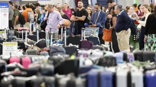 Travelers wait for their bags at the United Airlines baggage claim area at Los Angeles International Airport on June 29, 2023.