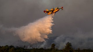 A Canadair CL-415 sprays water during a wildfire in the village of Pournari, near Athens, on July 18, 2023.