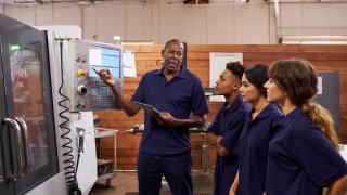 Engineer Training Apprentices On CNC Machine