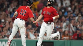 Boston Red Sox’s Enrique Hernandez, right, celebrates with Connor Wong (12) after scoring on a single by Rob Refsnyder against the Texas Rangers during the sixth inning of a baseball game Thursday, July 6, 2023, in Boston. (AP Photo/Steven Senne)