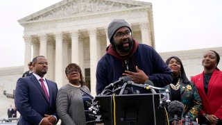 FILE – Evan Milligan, center, plaintiff in Merrill v. Milligan, an Alabama redistricting case that could have far-reaching effects on minority voting power across the United States, speaks with reporters following oral arguments at the Supreme Court in Washington, Oct. 4, 2022. (AP Photo/Patrick Semansky, File)