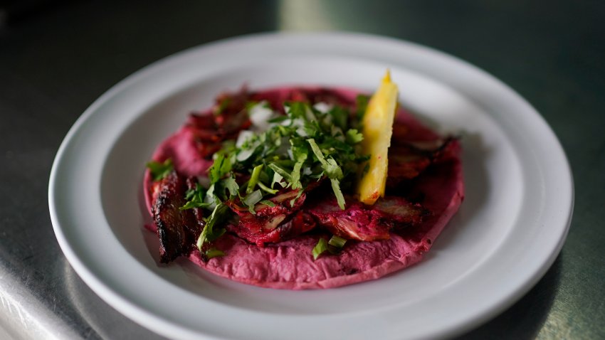 A cook prepares a taco with a Barbie theme pink tortilla at a restaurant in Mexico City, Thursday, July 20, 2023.