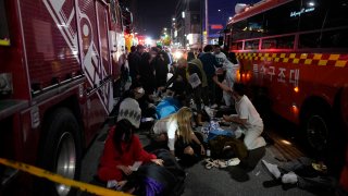 FILE – Injured people are helped at a street near the scene of a crush in Seoul, South Korea, on Oct. 30, 2022. South Korea’s Constitutional Court on Tuesday, July 25, 2023 rejected an attempt by lawmakers to oust the country’s public safety minister over the Halloween crowd surge that killed nearly 160 people last October at a nightlife district in the capital, Seoul.