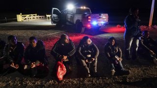 FILE – Migrants wait to be processed after crossing the border, Jan. 6, 2023, near Yuma, Ariz. A federal judge on Tuesday, July 25, blocked a rule that allows immigration authorities to deny asylum to migrants who arrive at the U.S.-Mexico border without first applying online or seeking protection in a country they passed through. But the judge delayed his ruling from taking effect immediately to give the administration time to appeal. (AP Photo/Gregory Bull, File)