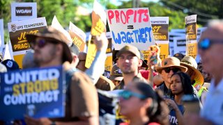 Members of the Writers Guild of America join UPS Teamsters during a rally ahead of possible UPS strike