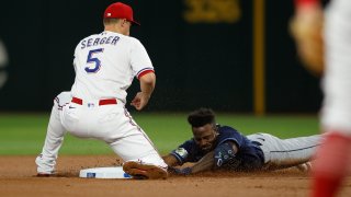 ARLINGTON, TEXAS – JULY 18: Randy Arozarena #56 of the Tampa Bay Rays slides safely into second base with a double in the second inning as Corey Seager #5 of the Texas Rangers applies the tag at Globe Life Field on July 18, 2023 in Arlington, Texas.