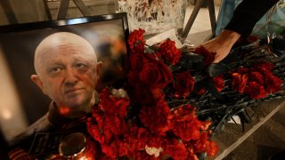 A man lays flowers at the makeshift memorial in honor of Yevgeny Prigozhin.