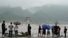 Residents look over an area inundated by flood waters in Miaofengshan on the outskirts of Beijing, Tuesday, Aug. 1, 2023.