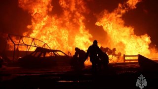 In this image provided by Russian Emergency Situations Ministry press service, firefighters work to extinguish a fire at a petrol station on a road near Makhachkala, the capital of Dagestan, Russia, late Monday, Aug. 14, 2023.