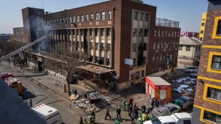 Medics and emergency works at the scene of a deadly blaze in downtown Johannesburg Thursday, Aug. 31, 2023.