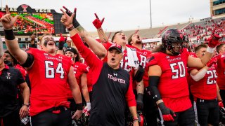 LUBBOCK, TEXAS – OCTOBER 22: Head coach Joey McGuire of the Texas Tech Red Raiders stands with his players after the game against the West Virginia Mountaineers at Jones AT&T Stadium on October 22, 2022 in Lubbock, Texas.