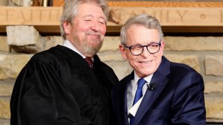 Ohio Governor Mike DeWine, right, shakes hands with Judge Thomas Rose of the U.S. District Court Southern District of Ohio after taking his oath of office, Monday, Jan. 14, 2019, in Cedarville, Ohio.