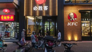Pedestrians walk past a Pizza Hut restaurant and a KFC restaurant, both operated by Yum China, in Beijing, China, on Sept. 5, 2020.
