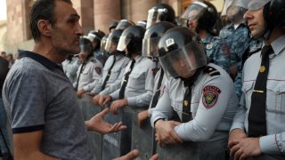 A protestor speaks with Armenian police officers as they guard the entrance to the Government House during a rally in Yerevan on September 21, 2023, following Azerbaijani military operations against Armenian separatist forces in Nagorno-Karabakh.