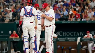 Texas Rangers catcher Jonah Heim, left, stands by as manager Bruce Bochy, right, takes the ball from relief pitcher Josh Sborz, center, in the seventh inning of a baseball game against the Texas Rangers, Monday, Sept. 4, 2023, in Arlington, Texas. (AP Photo/Tony Gutierrez)