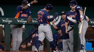 Houston Astros’ Jose Altuve (27) celebrates with manager Dusty Baker Jr., left, Alex Bregman, right, and the rest of the team after hitting a solo home run in the second inning of a baseball game against the Texas Rangers, Tuesday, Sept. 5, 2023, in Arlington, Texas.