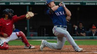 Texas Rangers’ Corey Seager, right, ducks away from an inside pitch by Cleveland Guardians starter Tanner Bibee as Guardians’ Bo Naylor, left, makes a catch during the third inning of a baseball game in Cleveland, Saturday, Sept. 16, 2023.