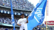 LOS ANGELES, CA - OCTOBER 24:  Actor George Lopez waves a Dodger flag on top of the dugout prior to Game 1 of the 2017 World Series between the Houston Astros and the Los Angeles Dodgers at Dodger Stadium on Tuesday, October 24, 2017 in Los Angeles, California. (Photo by Rob Tringali/MLB via Getty Images)