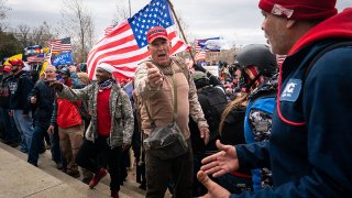 FILE - Ray Epps, in the red Trump hat, center, gestures as people gather on the West Front of the U.S. Capitol on Jan. 6, 2021, in Washington, D.C.