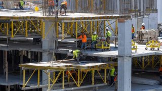Construction workers erect a building in downtown Miami, Florida, on June 14, 2023.