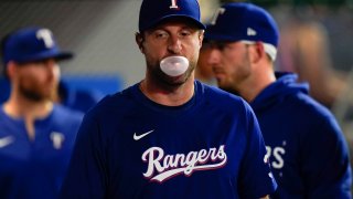 Texas Rangers pitcher Max Scherzer blows a gum bubble in the dugout during the second inning of a baseball game against the Los Angeles Angels, Monday, Sept. 25, 2023, in Anaheim, Calif.