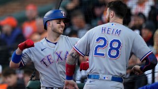 Texas Rangers’ Mitch Garver, left, celebrates his grand slam with Jonah Heim (28) during the third inning in Game 2 of an American League Division Series baseball game against the Baltimore Orioles, Sunday, Oct. 8, 2023, in Baltimore. (AP Photo/Alex Brandon)