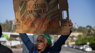 A member of the reproductive rights organization “Colectiva Bloodys y Projects” holds a sign that reads in Spanish “Not wanting to be a mother is reason enough. Free, safe abortion,” outside a public hospital in Tijuana, Mexico, Thursday, Sept. 28, 2023. The organization, which has supported reproductive rights near the U.S.-Mexico border since 2016, is made of up dozens of Mexican volunteers who support women wanting to terminate a pregnancy, offering virtual guidance through an abortion protocol in which no clinics or prescriptions are needed.