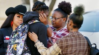 Darryl George, center left, a 17-year-old junior, and his mother Darresha George, center right, share words of encouragement before walking across the street to go into Barbers Hill High School after Darryl served a 5-day in-school suspension for not cutting his hair Monday, Sept. 18, 2023, in Mont Belvieu. George began attending a disciplinary program this week away from his classmates and regular teachers. He said in an interview with The Associated Press that he has felt isolated from and discouraged about not being able to play football or be more involved in campus events.