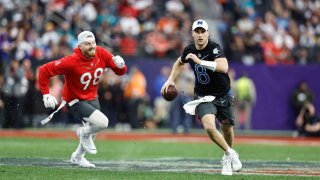 NFC quarterback Kirk Cousins of the Minnesota Vikings scrambles and looks to pass as he evades a tag from AFC defensive end Maxx Crosby of the Las Vegas Raiders during an NFL Pro Bowl football game at Allegiant Stadium on Feb. 5, 2023.