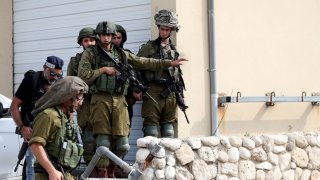 Israeli soldiers and police gather following a mass infiltration by Hamas gunmen from the Gaza Strip, in Sderot, southern Israel, Oct. 8, 2023.