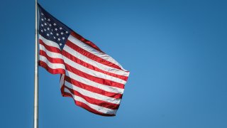 USA American flag flying against Blue Sky