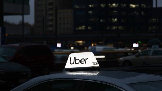 Uber taxi sign is seen on a car