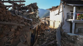 Residents walk amid the rubble of damaged homes in Jajarkot district on November 4, 2023, following an overnight a 5.6-magnitude earthquake. At least 132 people were killed in an overnight earthquake of 5.6-magnitude that struck a remote pocket of Nepal, officials said on November 4, as security forces rushed to assist with rescue efforts. (Photo by PRAKASH MATHEMA / AFP) (Photo by PRAKASH MATHEMA/AFP via Getty Images)