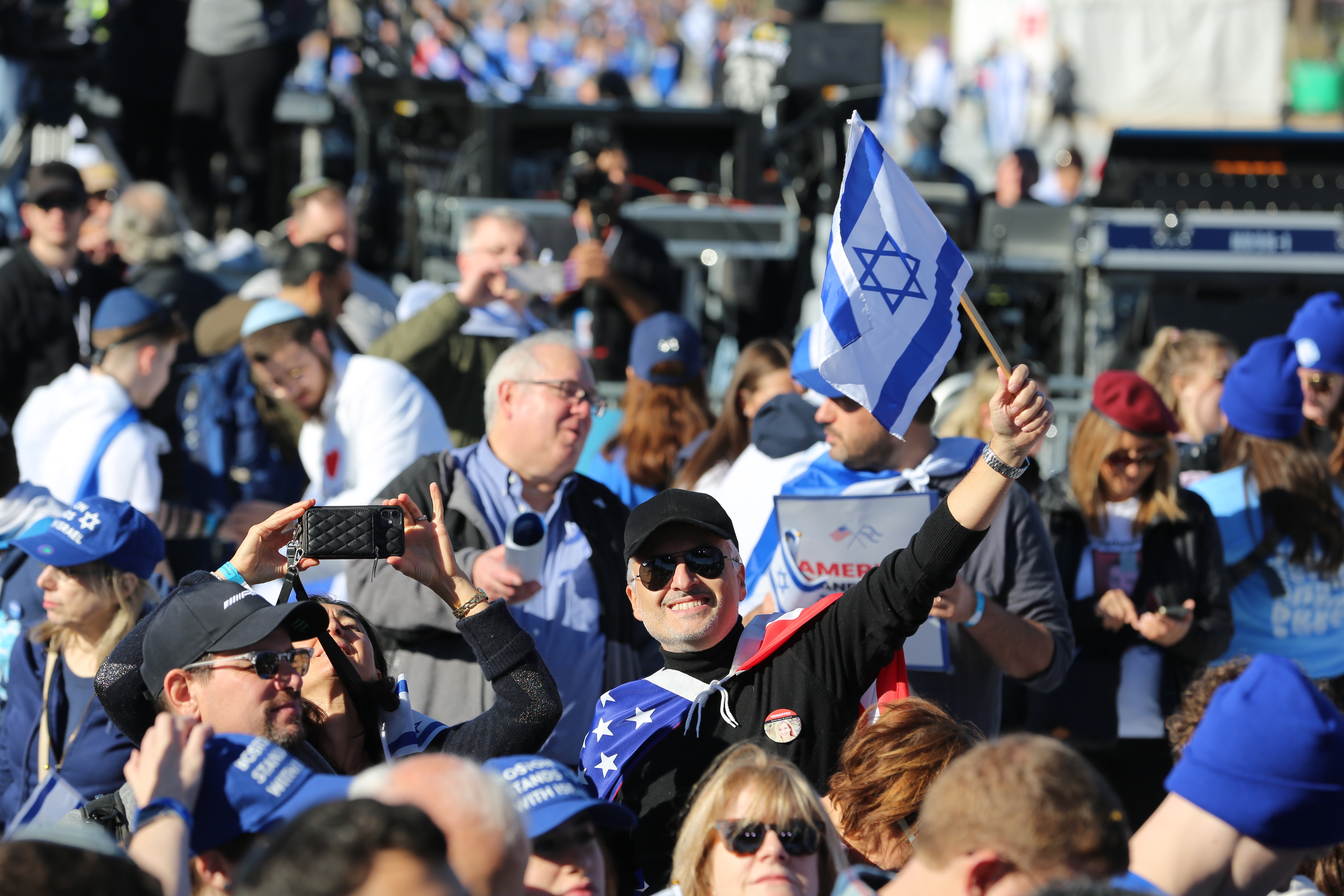 A man in the crowd waves an Israeli flag at the March for Israel at the National Mall on Tuesday, November 14, 2023 in Washington, DC.