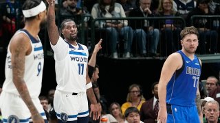 Minnesota Timberwolves center Naz Reid (11) reacts after hitting a 3-point basket as Dallas Mavericks guard Luka Doncic (77) looks on during the first half of an NBA basketball game in Dallas, Thursday, Dec. 14, 2023.