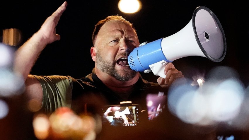 Alex Jones speaks into a bullhorn at a rally.